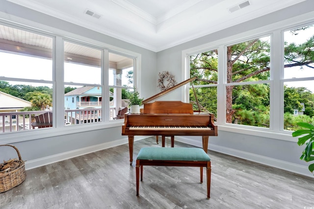 living area with wood finished floors, visible vents, and baseboards