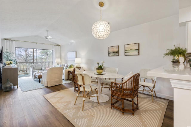 dining room featuring baseboards, a ceiling fan, vaulted ceiling, and wood finished floors