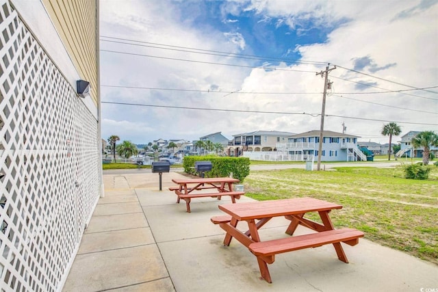 view of home's community with a patio area, a residential view, and a lawn