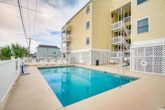 community pool featuring a patio and fence