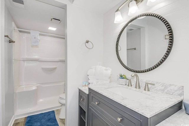 full bathroom featuring visible vents, toilet, walk in shower, and vanity