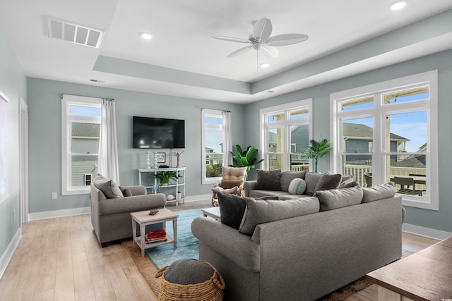 living room featuring recessed lighting, baseboards, visible vents, and light wood-type flooring