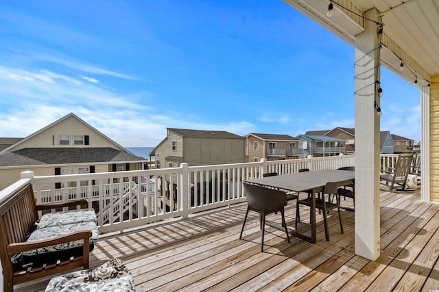 deck with outdoor dining area and a residential view