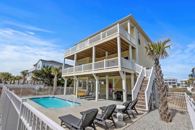 back of house featuring a patio area, a fenced in pool, stairs, and fence