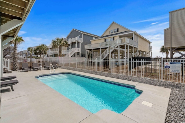 community pool with stairway, a patio area, and fence