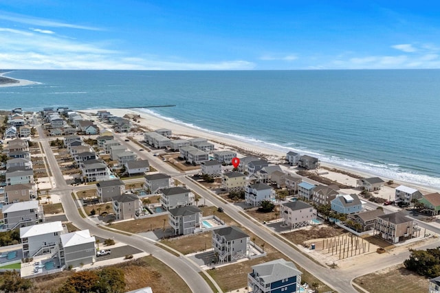 birds eye view of property featuring a beach view and a water view