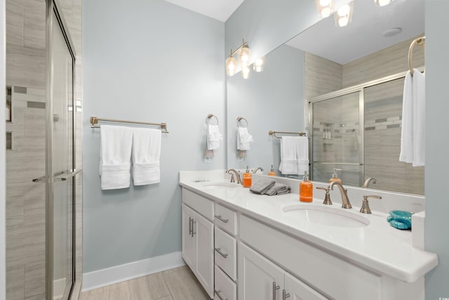 bathroom with a shower stall, baseboards, and a sink