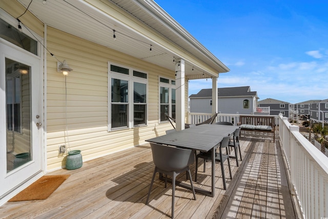 wooden deck with outdoor dining area and a residential view