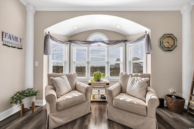 sitting room featuring ornate columns, baseboards, dark wood finished floors, and ornamental molding