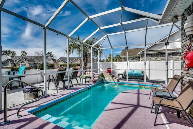 view of pool featuring glass enclosure, fence, a fenced in pool, and a patio