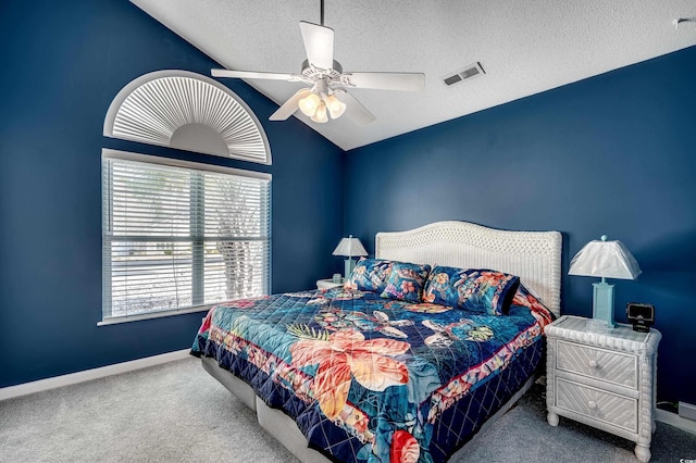 carpeted bedroom featuring baseboards, visible vents, a ceiling fan, vaulted ceiling, and a textured ceiling