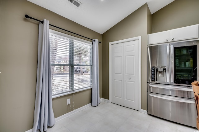 kitchen with baseboards, white cabinets, visible vents, stainless steel fridge with ice dispenser, and vaulted ceiling