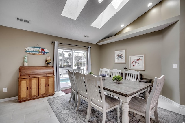 dining space featuring lofted ceiling with skylight, baseboards, light tile patterned floors, and visible vents