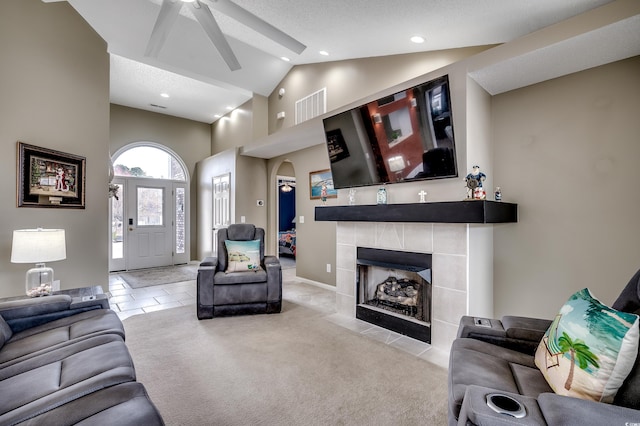 carpeted living room featuring visible vents, arched walkways, a fireplace, high vaulted ceiling, and recessed lighting