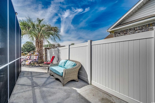 view of patio / terrace featuring a lanai and fence