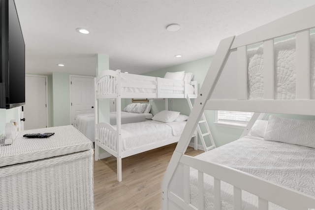 bedroom featuring light wood finished floors, recessed lighting, and a textured ceiling