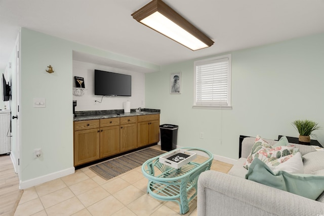 living room with light tile patterned floors, baseboards, and washer / clothes dryer