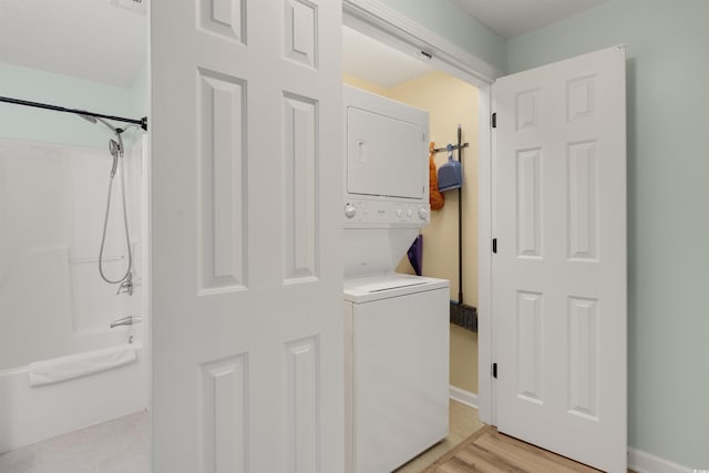 washroom featuring light wood finished floors, laundry area, and stacked washer / drying machine