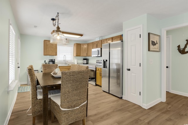 dining space featuring light wood-type flooring and baseboards