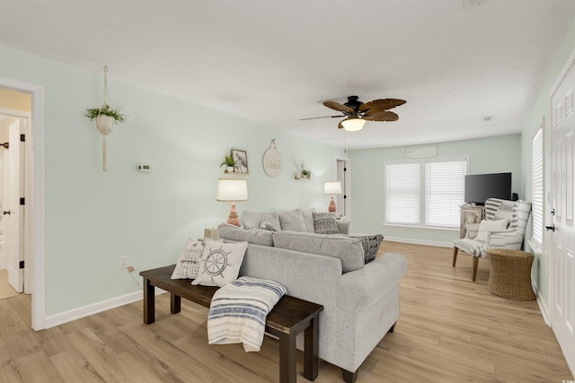 living area with ceiling fan, light wood-type flooring, and baseboards