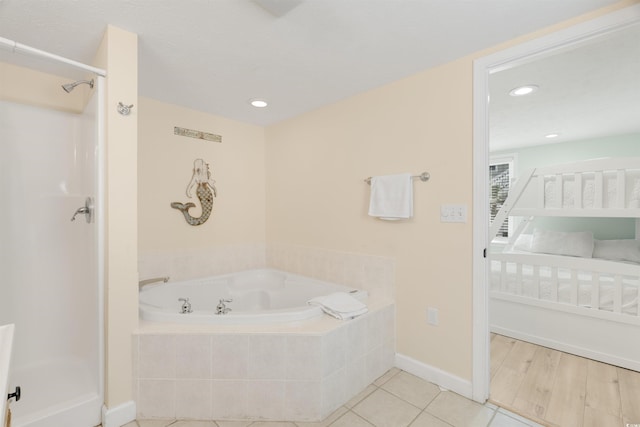 bathroom with baseboards, recessed lighting, a shower stall, a garden tub, and tile patterned floors