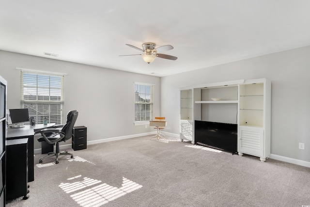 unfurnished office featuring a ceiling fan, carpet flooring, visible vents, and baseboards