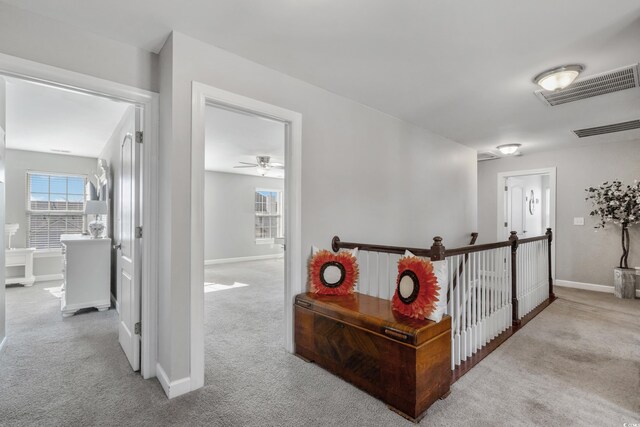 corridor featuring carpet, visible vents, and baseboards