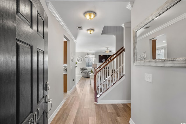 foyer with stairs, visible vents, and crown molding