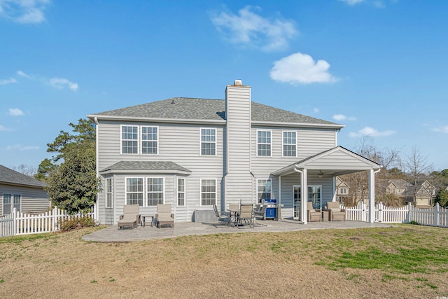 rear view of property with a fenced backyard, a lawn, and a patio