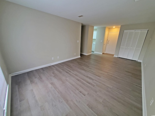 unfurnished bedroom with visible vents, baseboards, and wood finished floors