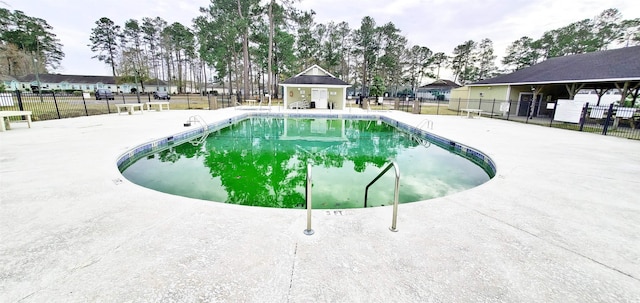 pool with a patio area and fence