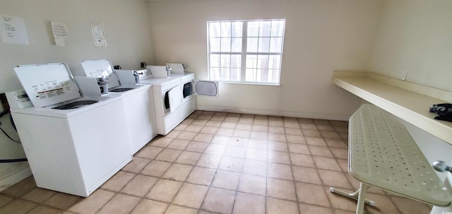 community laundry room featuring baseboards and washer and dryer