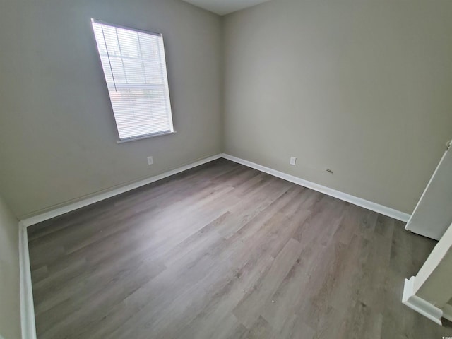 empty room with baseboards and dark wood finished floors