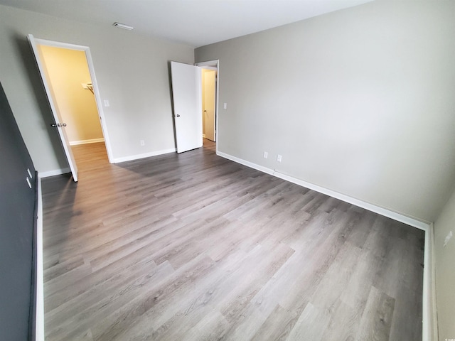 unfurnished bedroom with baseboards and wood finished floors