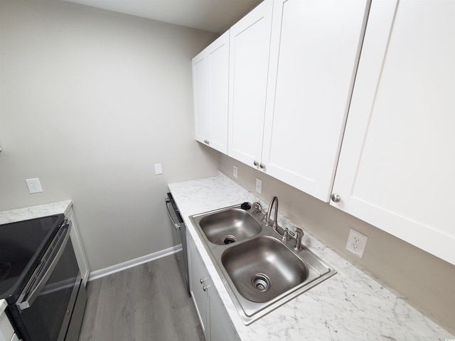 kitchen featuring a sink, baseboards, white cabinets, stainless steel dishwasher, and electric range oven