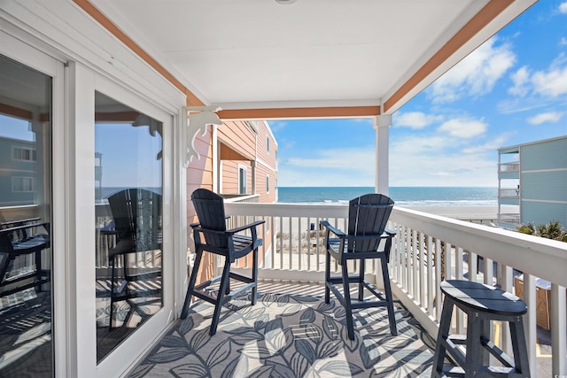 balcony featuring a water view and a view of the beach