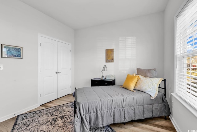 bedroom featuring a closet, wood finished floors, and baseboards