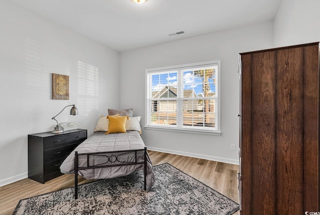 sitting room with light wood finished floors, visible vents, and baseboards