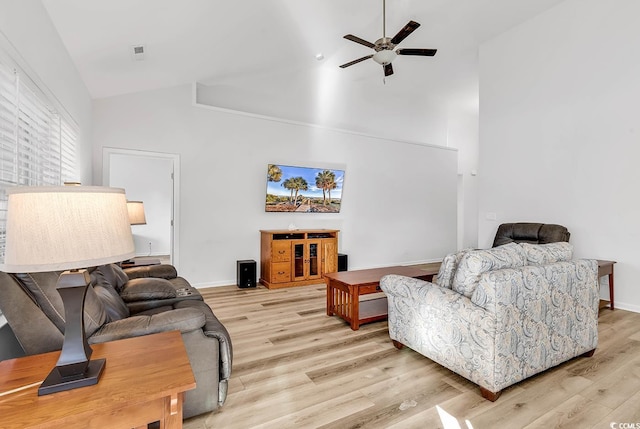 living area with ceiling fan, high vaulted ceiling, light wood-type flooring, and baseboards