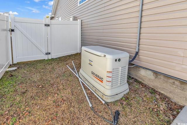 exterior details featuring a gate, fence, and a power unit