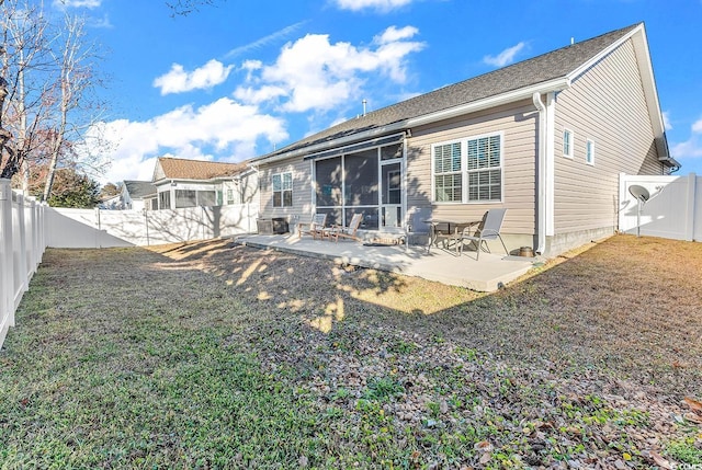 rear view of property featuring a sunroom, a fenced backyard, a patio, and a lawn