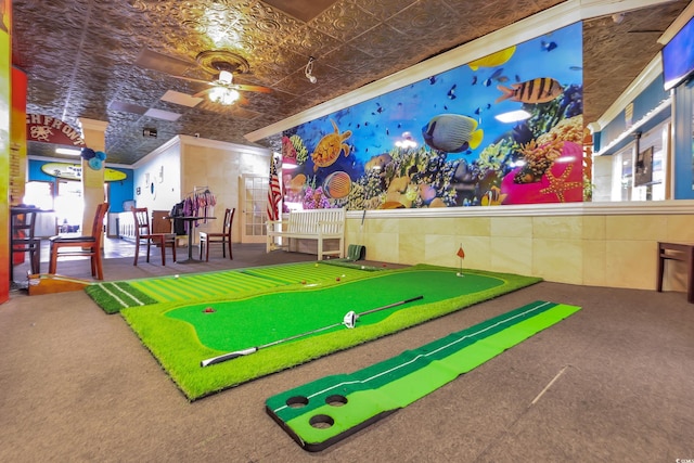 rec room featuring crown molding, ceiling fan, carpet flooring, plenty of natural light, and an ornate ceiling