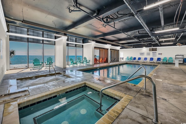 community pool with a water view and an indoor in ground hot tub