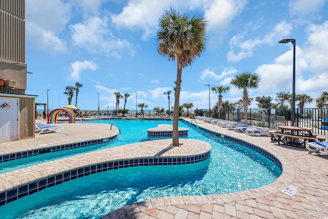 pool with a patio area and fence