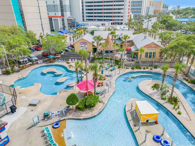 community pool with a city view, a water play area, and a hot tub