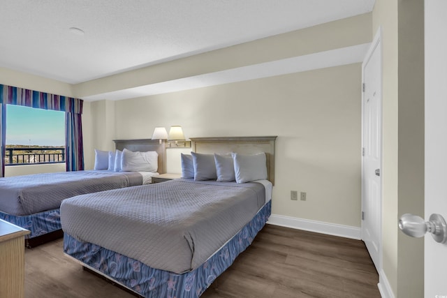 bedroom featuring wood finished floors and baseboards