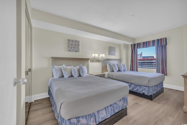 bedroom with baseboards and wood finished floors