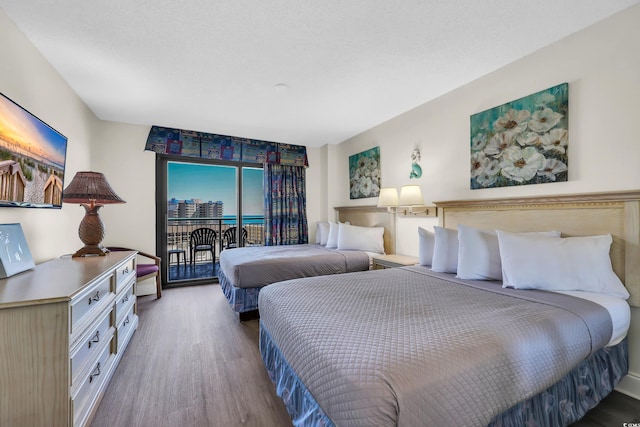 bedroom featuring wood finished floors and access to outside