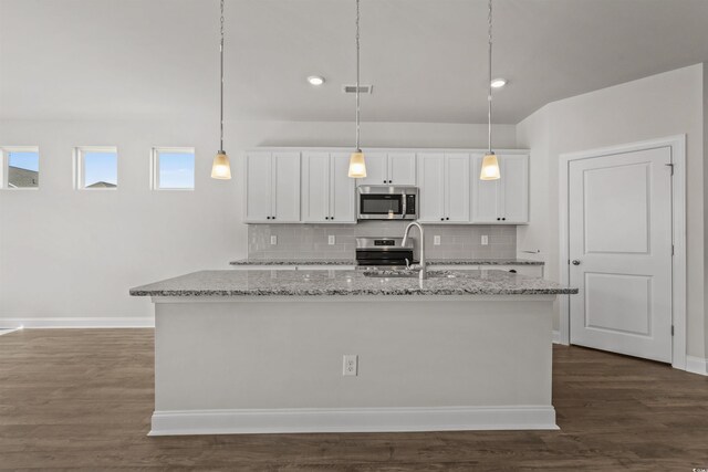 1204 NW Calabash Station Blvd, Calabash, NC 28467 - kitchen with tasteful backsplash, appliances with stainless steel finishes, white cabinets, visible vents, and a center island with sink