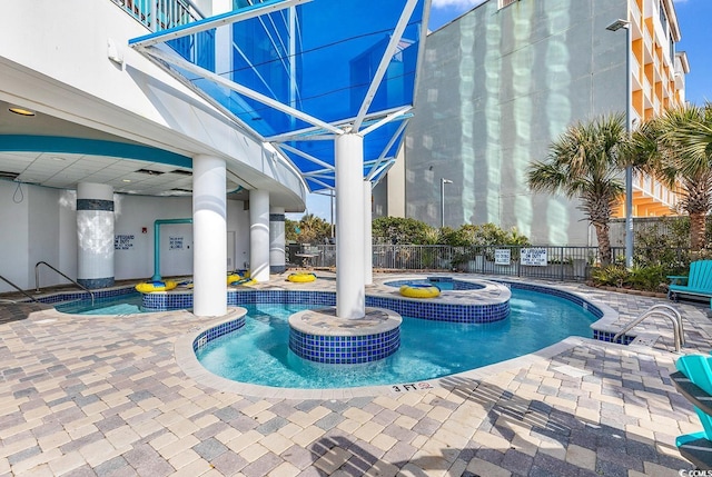 pool featuring a hot tub, fence, and a patio